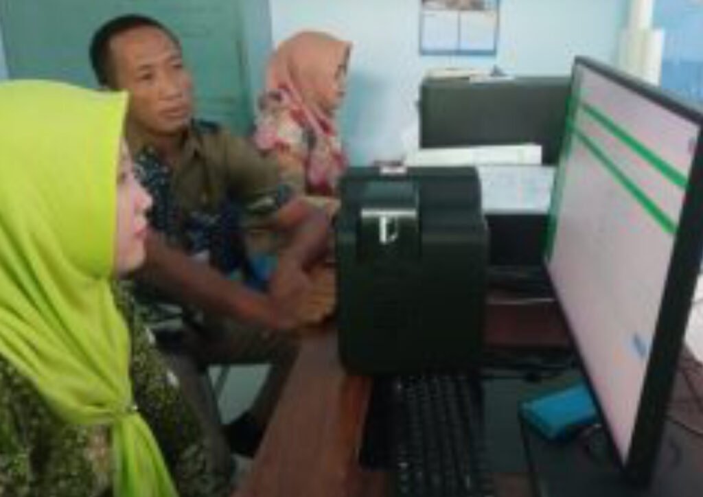 Foto: Pegawai Kantor Kecamatan Pancur sedang memproses pencetakan E-KTP (Sumber: rembangkab)